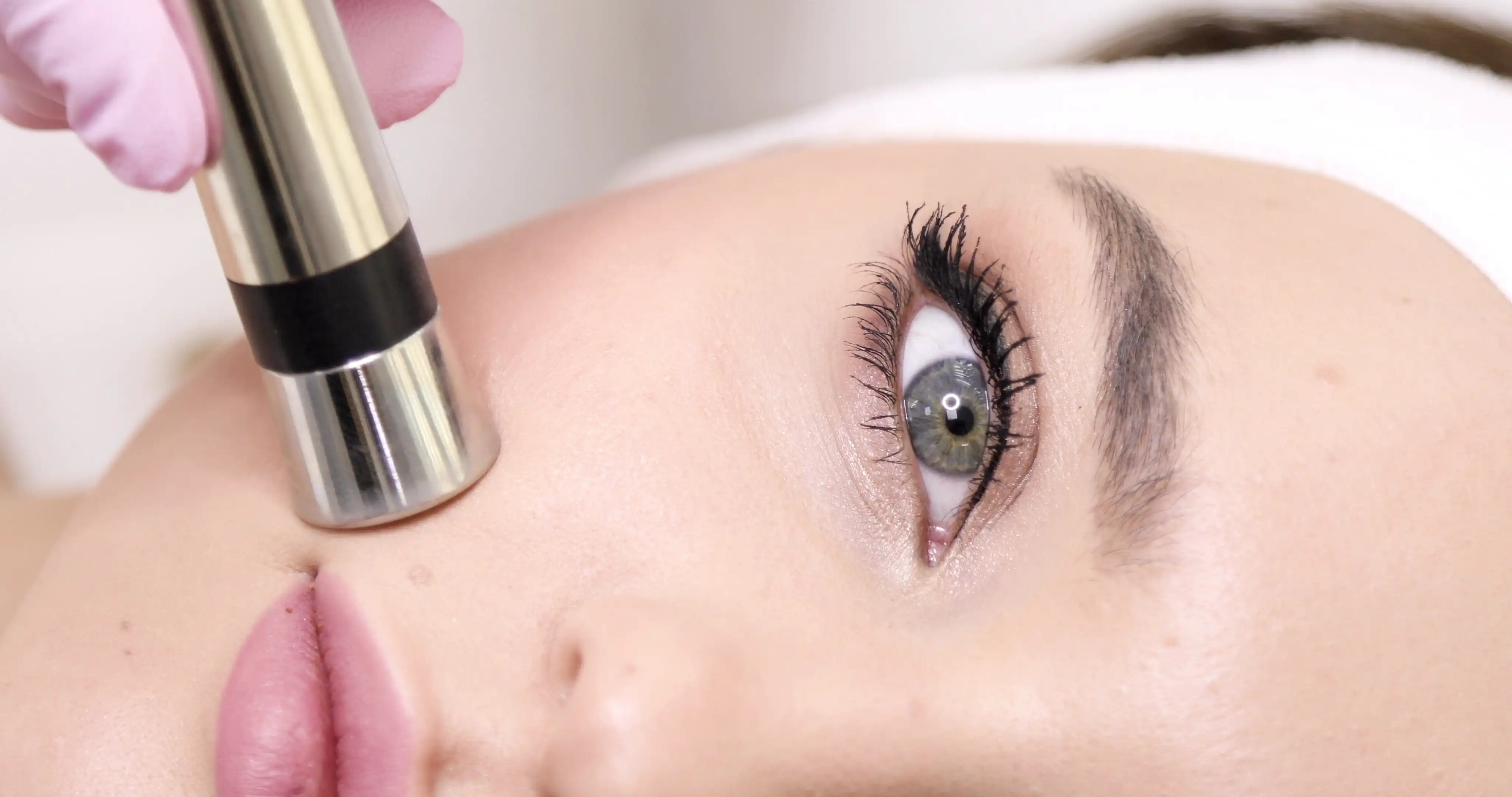 Professional esthetician performing microdermabrasion treatment for skin rejuvenation