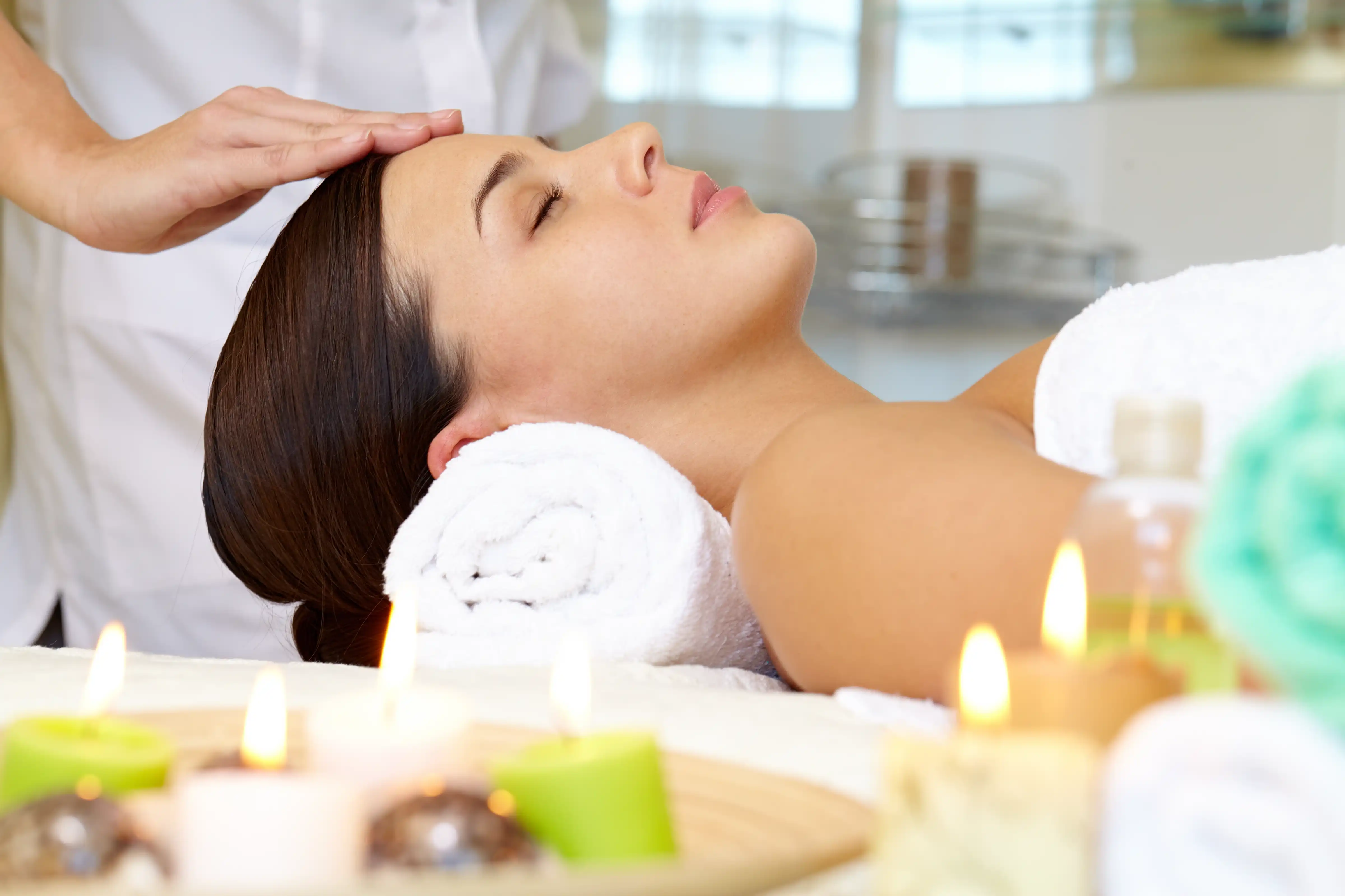 Serene spa environment with ambient lighting and candles, creating a relaxing atmosphere for facial treatments
